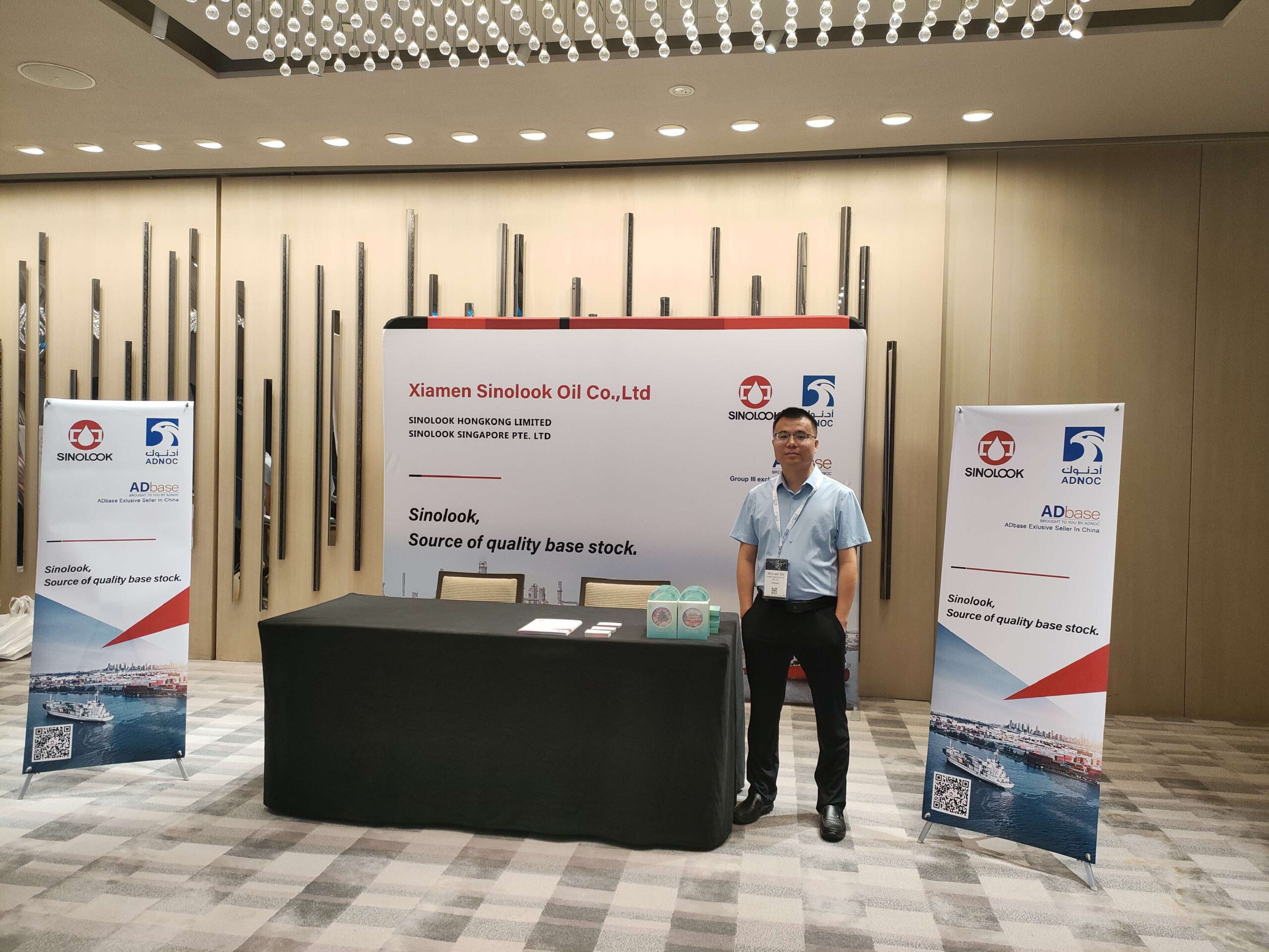 Xiamen Sinolook Oil booth at the 18th ICIS Asian Base Oils and Lubricants Conference in Singapore, featuring the ADNOC ADbase Group III exclusive distributor branding.